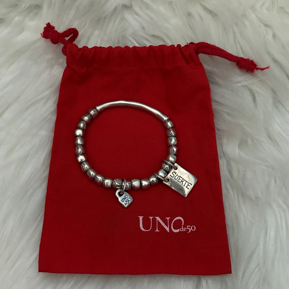 UNO de 50 Silver beaded stretch bracelet with tubular piece and a charm.